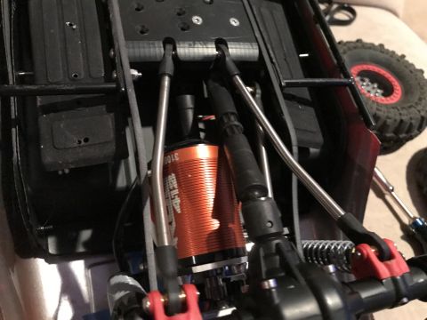 1989 Ford Bronco - Close-up view of the internal components of a remote control car, highlighting the orange motor and suspension system.
