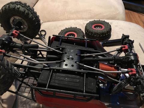 1989 Ford Bronco - The chassis of a remote-controlled crawler vehicle is shown, with its suspension and motor visible.
