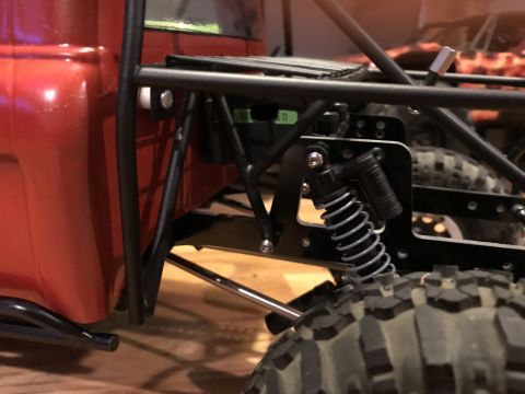 1989 Ford Bronco - Close-up view of the suspension and tire on a red vehicle chassis, suggesting an off-road or custom build.