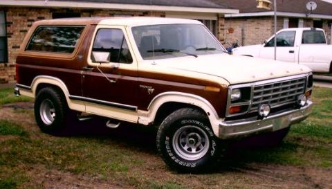 1980 Ford Bronco - Two-tone 1980 Ford Bronco parked outside a house with a white pickup truck behind it.
