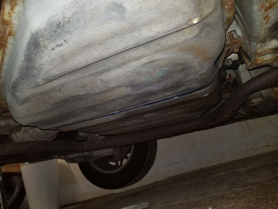 Underside view of a vehicle showing the fuel tank and exhaust system