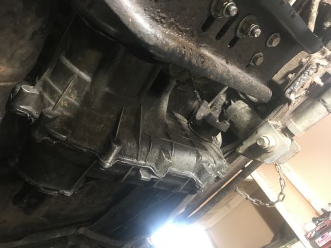 1989 Ford Bronco - Underside view of a vehicle's transmission housing and associated mechanical parts.
