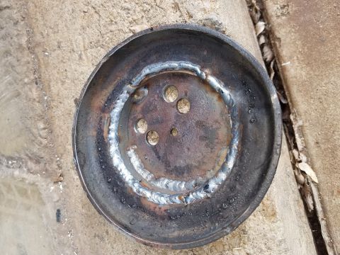 1995 Ford Bronco - A metal part, possibly a brake drum or pulley, shows recent welding work.