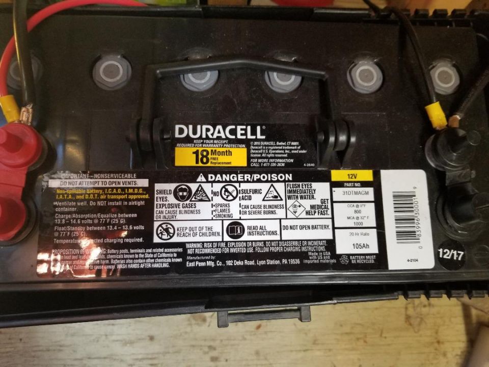 Duracell car battery with 18-month warranty and danger/poison warnings