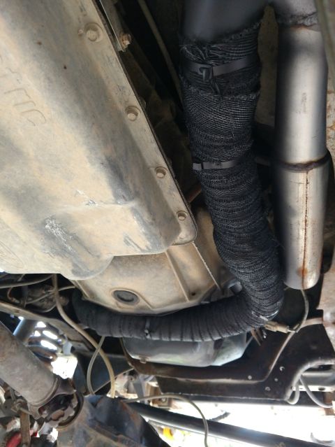 1992 Ford Bronco - Underside view of an exhaust pipe covered in black heat wrap, likely for insulation purposes.