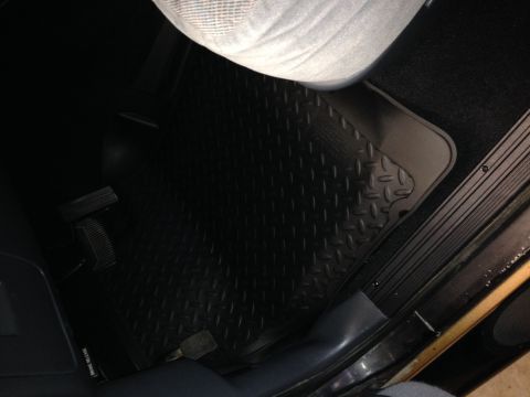 1995 Ford Bronco - Close-up of a black diamond plate floor mat inside a vehicle, showing the driver's side footwell area.