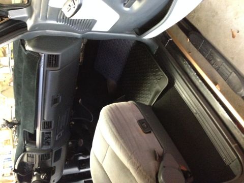 1995 Ford Bronco - The interior of a vehicle is shown, gray seats and black floormats.