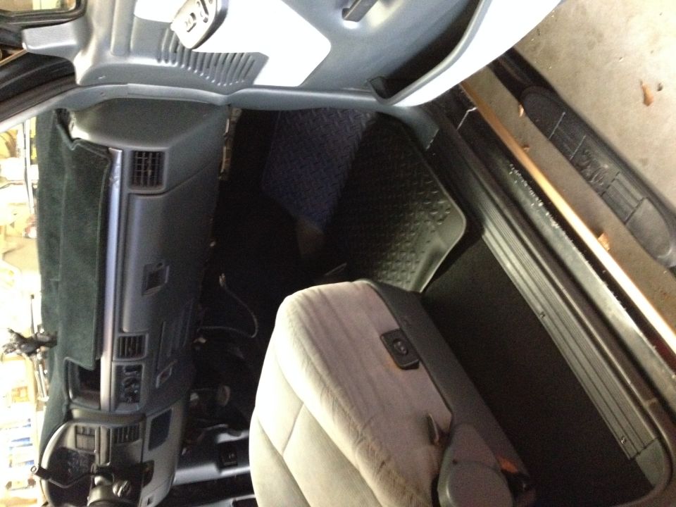 Interior view of a vehicle with gray seats and black floormats