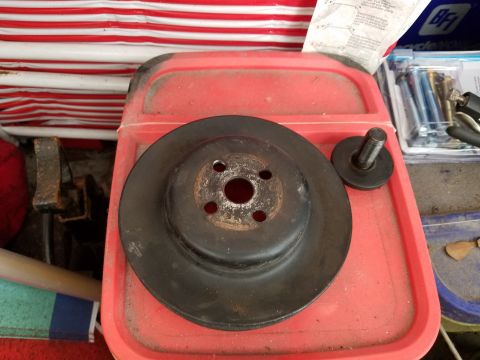 1976 Ford Ranchero - Pulley and bolt on a red tray with some hardware in the background.