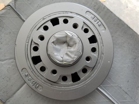 1976 Ford Ranchero - A gray crankshaft pulley, likely a replacement part, is shown with tape covering its center hub.