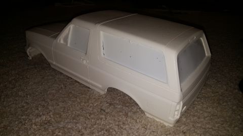 1996 Ford Bronco - This is an unpainted model of an SUV body, possibly a Bronco, resting on a carpeted surface.