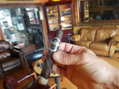 2018 Ford Bronco - A person holds a lit cigar in front of a lounge with leather furniture and display cases.