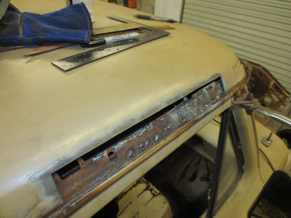 Close-up of a damaged truck roof with welding repairs in progress.