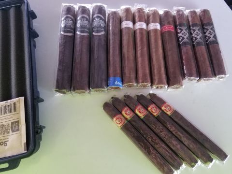 2018 Ford Bronco - A collection of cigars in plastic wrappers are laid out on a table next to a black case. Some of the cigars have colorful bands with text a…
