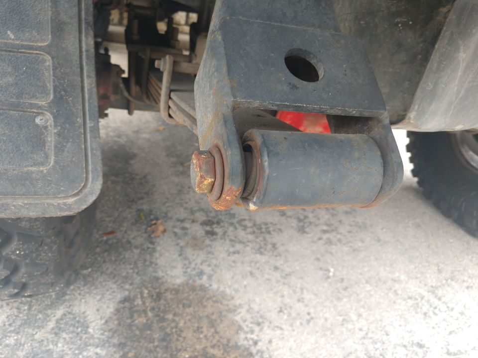1989 Ford Bronco rear suspension leaf spring shackle with rusty bolt and bushing.