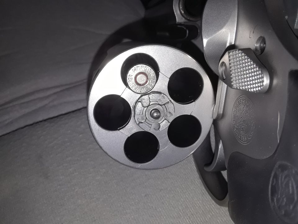Close-up of a revolver cylinder with one bullet.