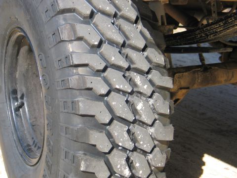 1995 Ford Bronco - A close-up view of a off-road tire, highlighting its deep tread pattern.