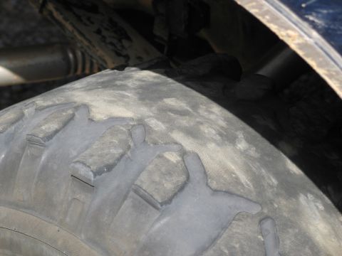 1995 Ford Bronco - Detail shot of a tire and suspension components, not a full vehicle view.