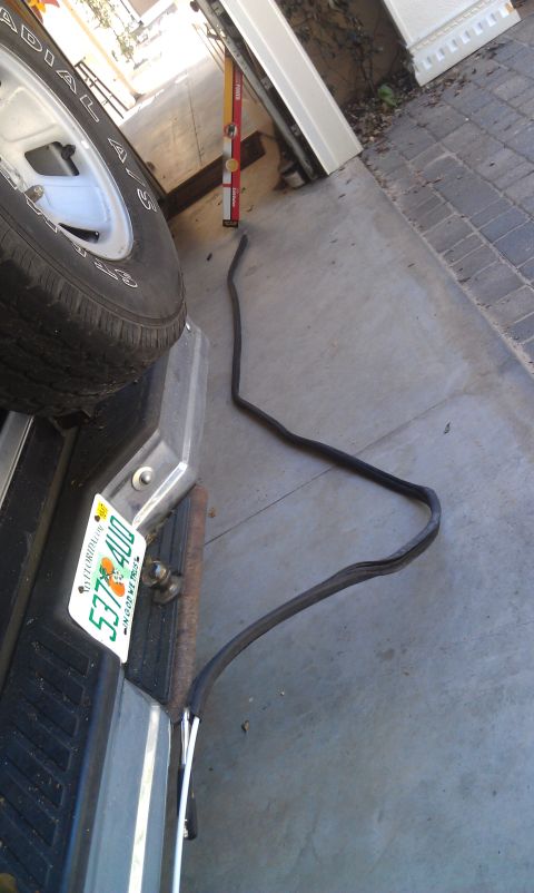 1995 Ford Bronco - A rubber seal is visible on a concrete driveway near a spare tire and license plate.
