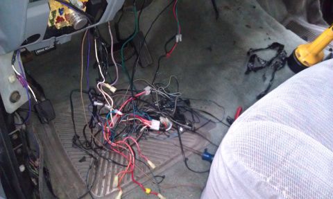 1995 Ford Bronco - A chaotic tangle of wires and connectors is visible on the floor of a vehicle's interior.