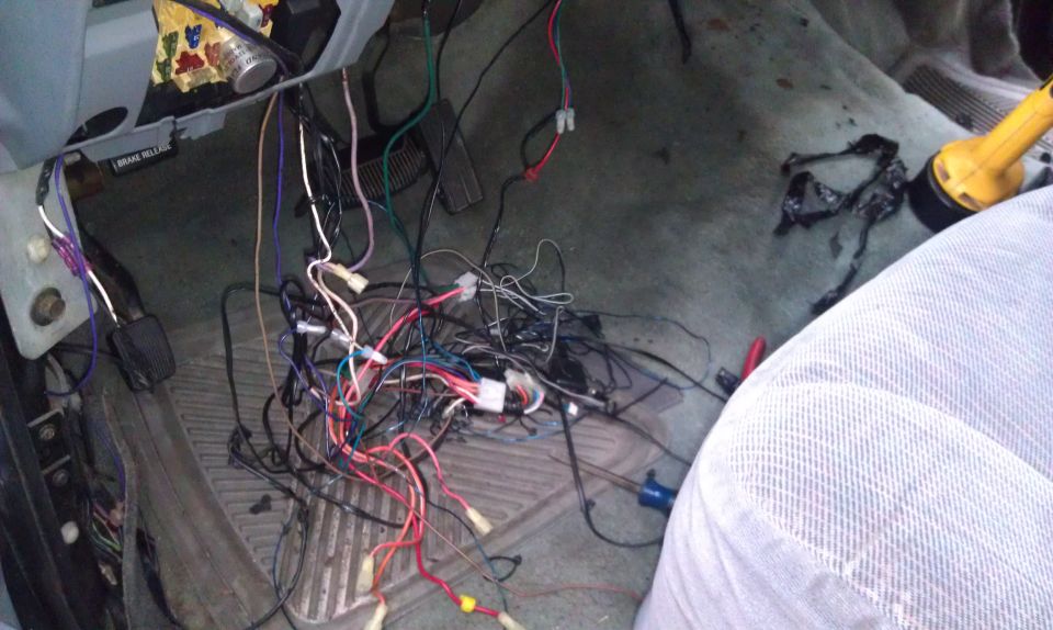 Mess of wires under dashboard, looks like an alarm system install gone wrong