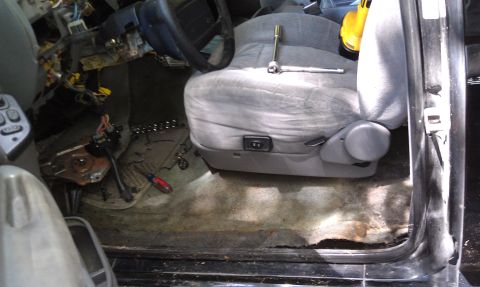 1995 Ford Bronco - The interior of a vehicle is shown with the dashboard disassembled and tools laid out, indicating ongoing work.