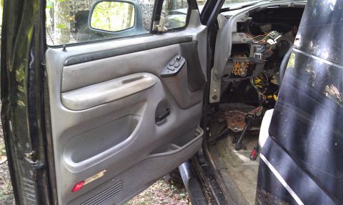 1995 Ford Bronco - The interior of a disassembled 1990s Ford truck or SUV, with exposed wiring and dashboard components, suggests a model year around 1990.