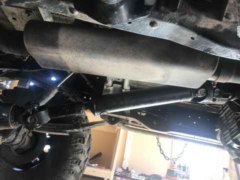 1989 Ford Bronco - Close-up view of the undercarriage, focusing on the driveshaft and exhaust system.