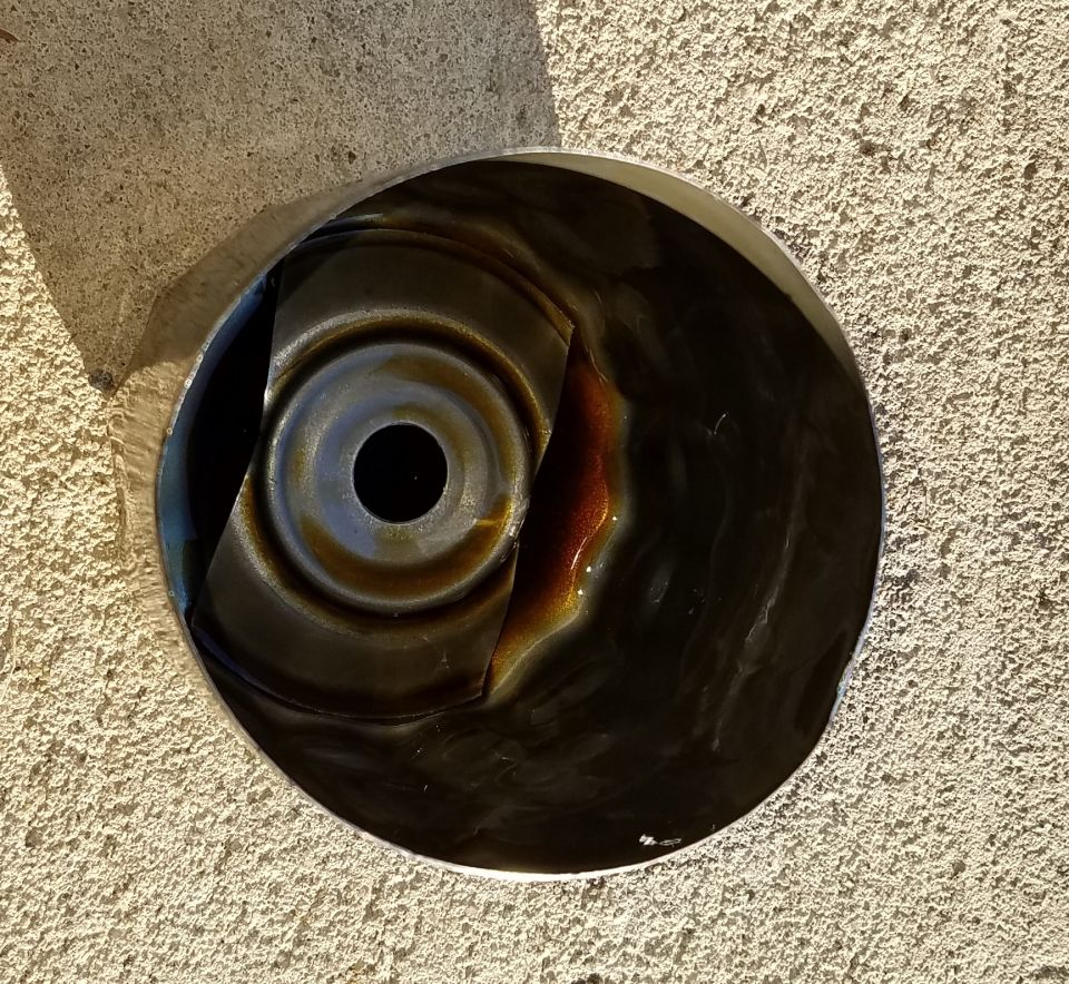 Close-up of a dirty oil pan with some oil residue inside