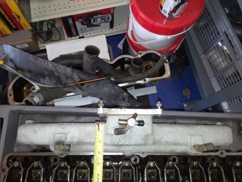 1985 Ford Bronco - Engine components are laid out, possibly for an engine rebuild, with a caution fan label and a measuring tape in view.