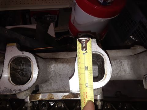 1985 Ford Bronco - Close-up of an engine intake manifold being measured with a tape measure.
