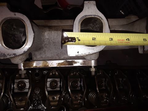 1985 Ford Bronco - Close-up of an engine part being measured, with rocker arms visible below.
