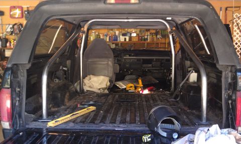 1995 Ford Bronco - The interior of a Ford Bronco is shown with a custom roll cage installed, ready for modifications.