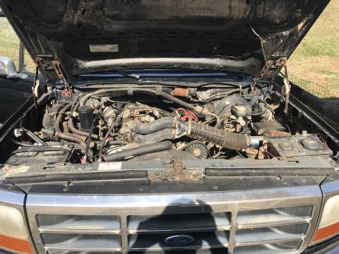 1992 Ford Bronco - Engine bay of a 1992 Ford Bronco, viewed from the front with the hood raised.