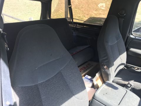 1992 Ford Bronco - The interior of a 1992 Ford Bronco is visible, cloth seats and a view of the rear bench.