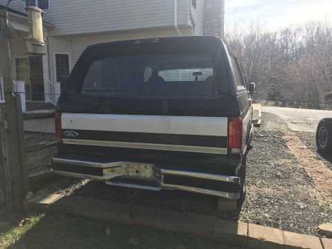 1992 Ford Bronco - Rear view of a 1992 Ford Bronco, showing its two-tone paint and chrome bumper.