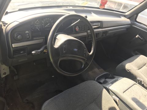 1992 Ford Bronco - The interior of a 1992 Ford Bronco, a worn dashboard and fabric seats.