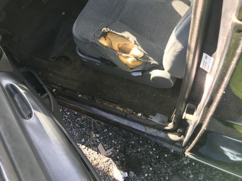 1992 Ford Bronco - The driver's seat shows significant wear and tear, with foam exposed through a large rip in the upholstery.
