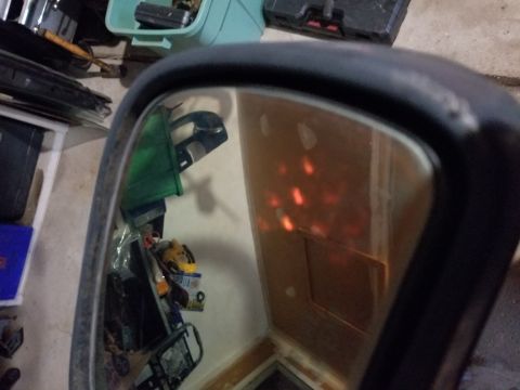 1995 Ford Bronco - The reflection in the side mirror reveals a cluttered interior with several orange lights visible.
