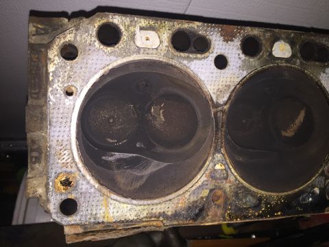 1967 Ford Custom Wagon - This is a close-up view of a used engine cylinder head, showing two combustion chambers with carbon buildup.