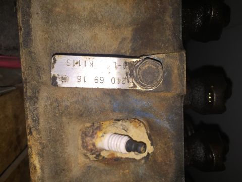 1967 Ford Custom Wagon - A metal identification tag and a spark plug are visible on a rusty engine part.