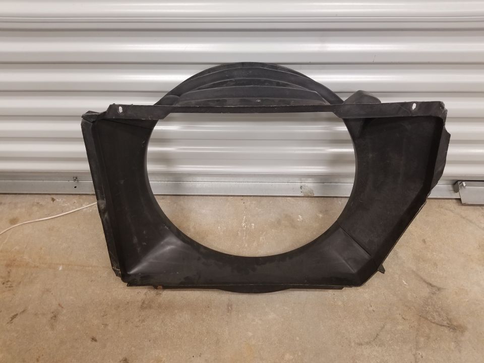 Black plastic radiator fan shroud with a large circular opening