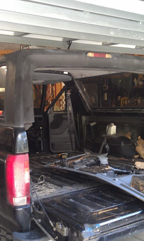 1995 Ford Bronco - The interior of the vehicle is exposed, with seats removed and parts of the bed disassembled.