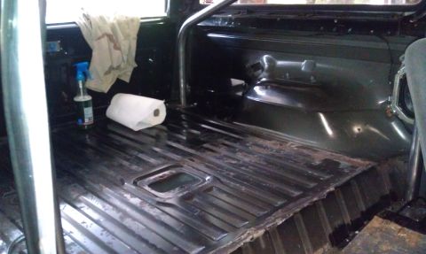 1995 Ford Bronco - The interior floor of a vehicle shows a roll bar and cleaning supplies.
