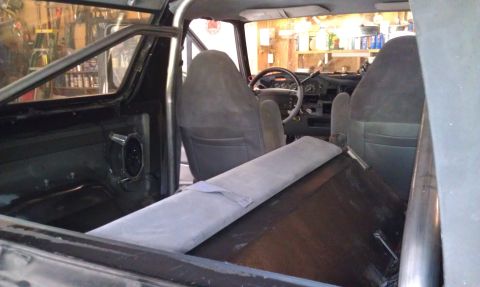 1995 Ford Bronco - The interior of a vehicle is shown, bucket seats, a roll cage, and a dashboard with gauges.