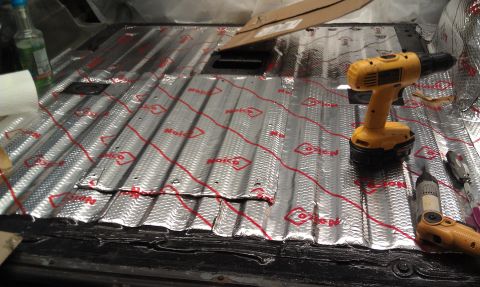 1995 Ford Bronco - Sound deadening material is being installed on the floor of a vehicle's interior.