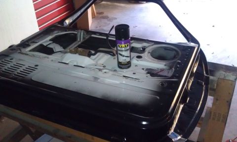 1995 Ford Bronco - Disassembled car door interior with a can of VHT spray paint.
