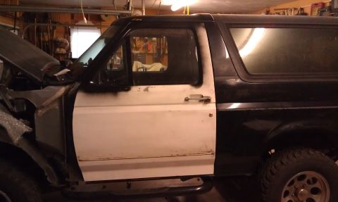 1995 Ford Bronco - This Ford Bronco appears to be undergoing some body work or repairs in a garage setting.