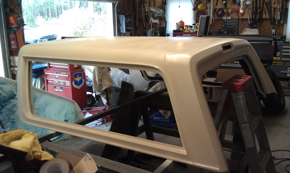 Cream-colored Ford Bronco topper in a garage, resting on sawhorses