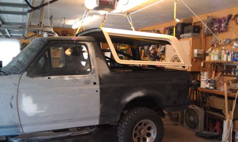 1995 Ford Bronco - A white 1995 Ford Bronco is captured from a 3q-front angle, highlighting its removable hardtop.